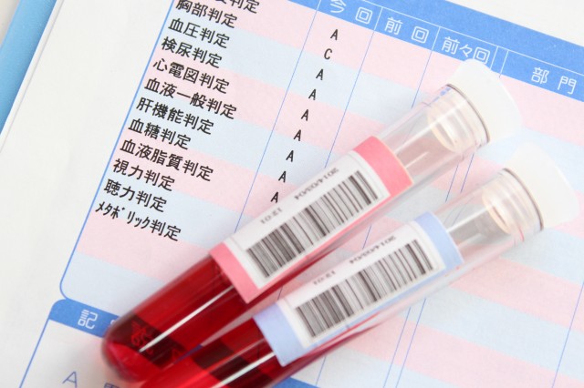 健康診断の結果用紙と容器に入った血液